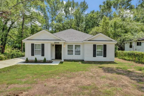 a front view of a house with a yard and trees