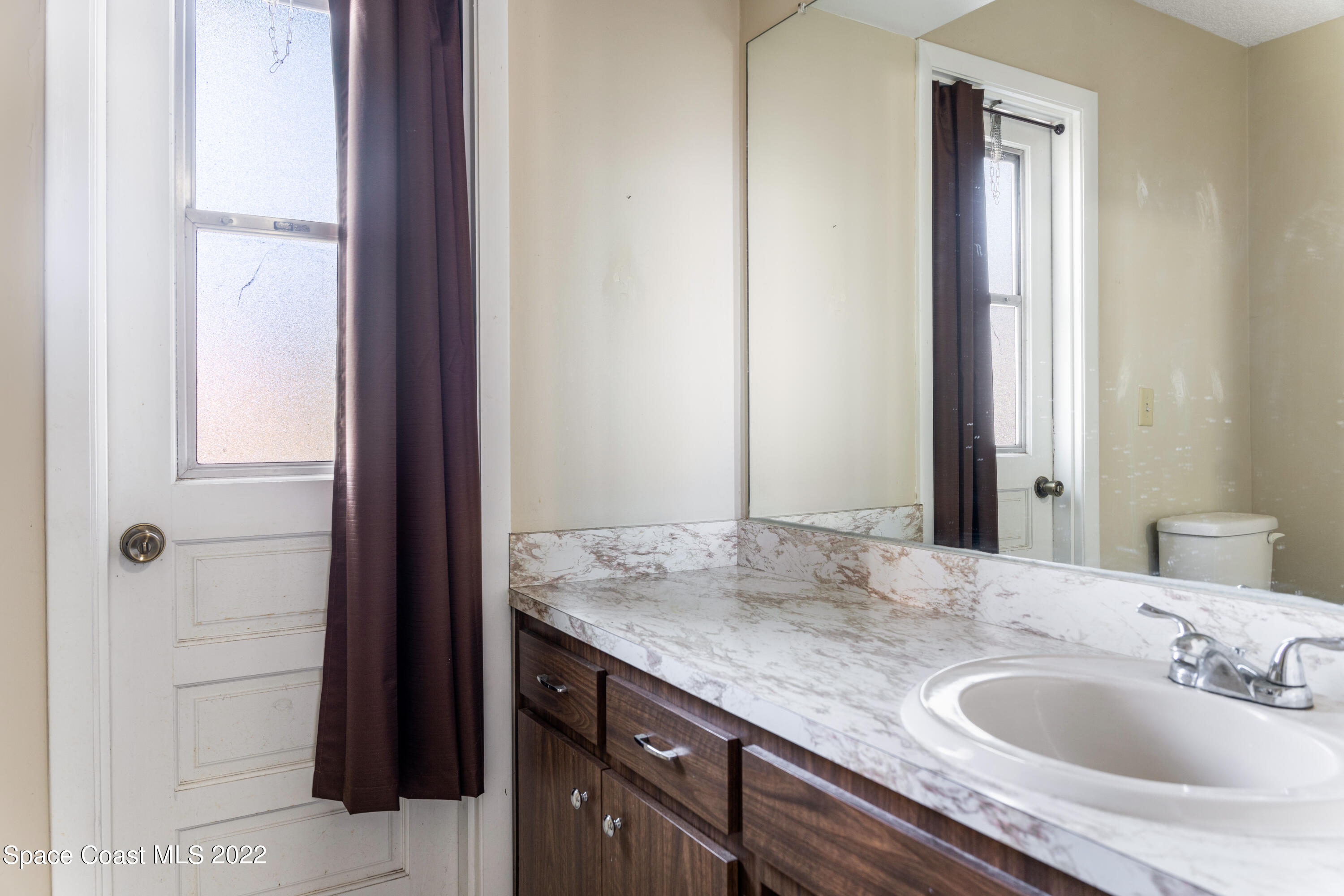 415 Cortez Road Palm Bay, FL 32907 - Photo 20 of 22 a bathroom with a granite countertop sink and a mirror
