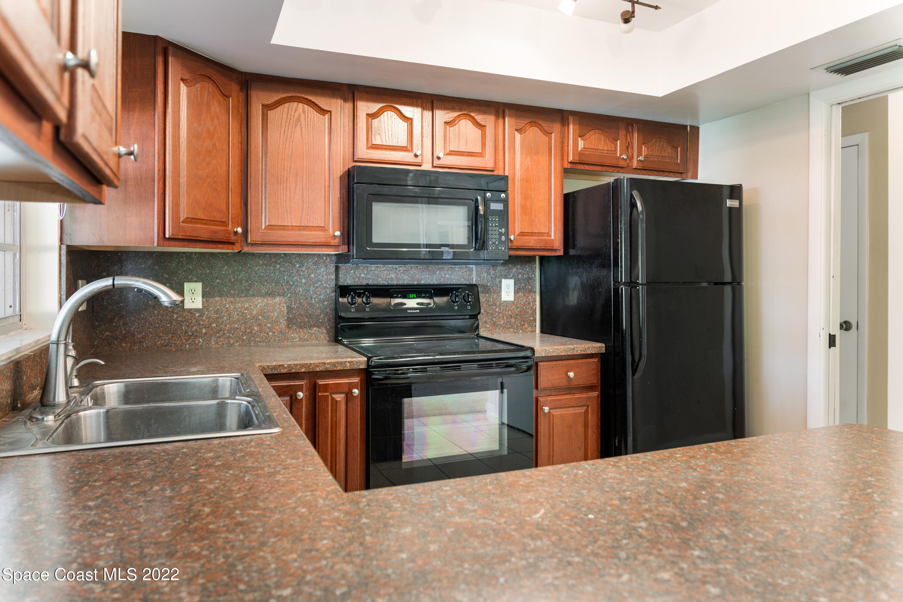 415 Cortez Road Palm Bay, FL 32907 - Photo 3 of 22 a kitchen with stainless steel appliances granite countertop a refrigerator stove and microwave
