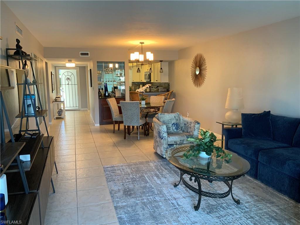 5530 Rattlesnake Hammock Road, Unit K103 Naples, FL 34112 - Photo 11 of 32 a living room with furniture a rug and a flat screen tv