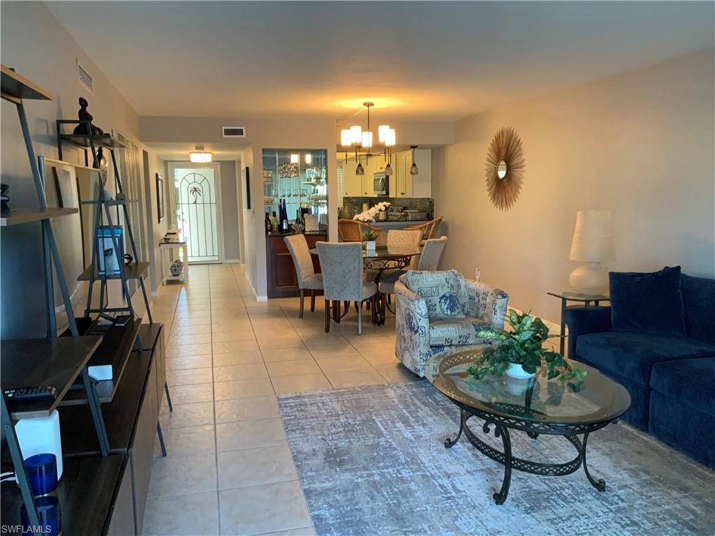 5530 Rattlesnake Hammock Road, Unit K103 Naples, FL 34112 - Photo 12 of 32 a living room with furniture a rug and a flat screen tv