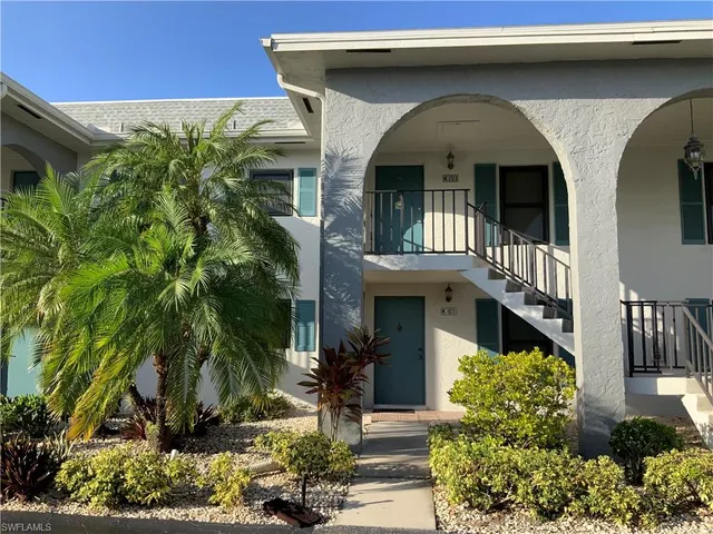 a bedroom with a bed and a lamp on dresser