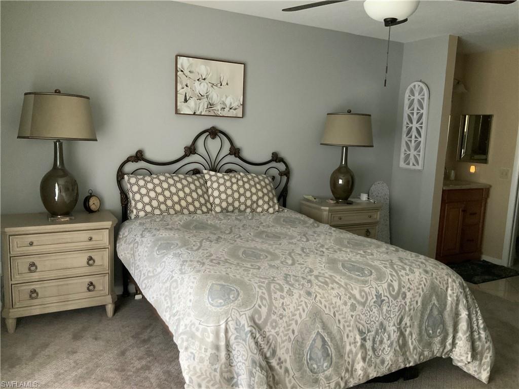 5530 Rattlesnake Hammock Road, Unit K103 Naples, FL 34112 - Photo 22 of 32 a bedroom with a bed and a lamp on dresser