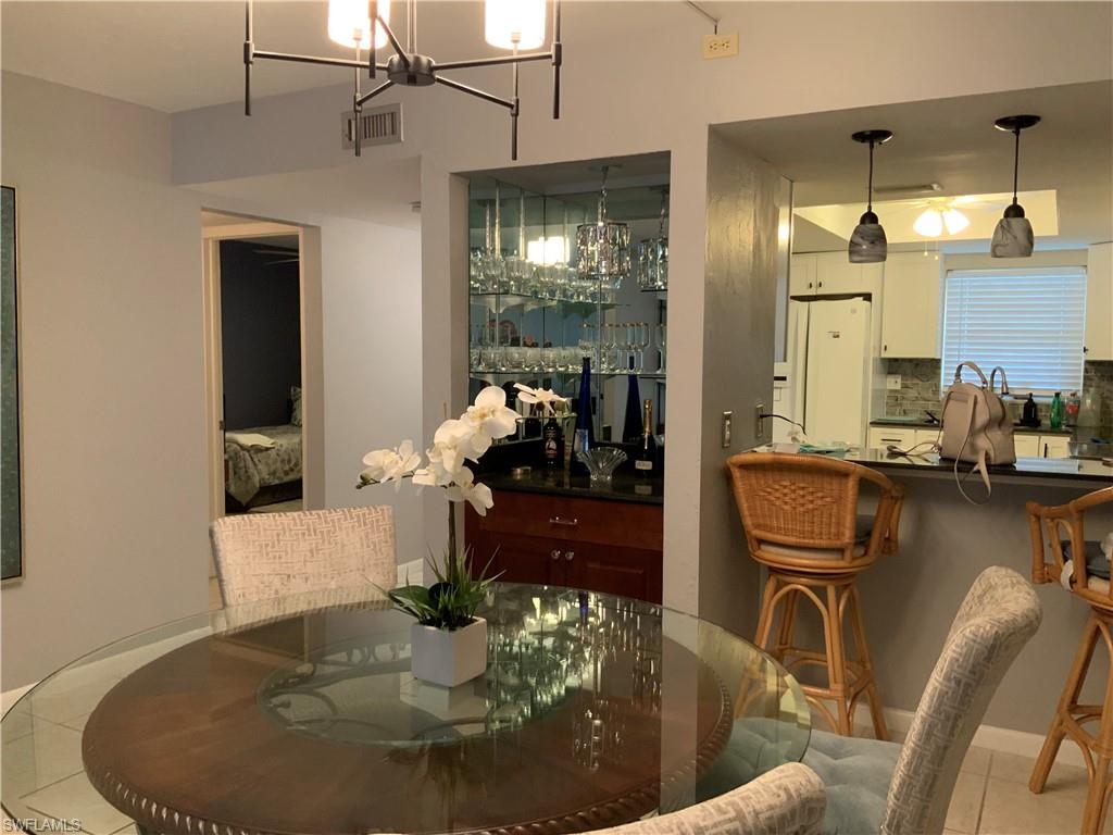 5530 Rattlesnake Hammock Road, Unit K103 Naples, FL 34112 - Photo 27 of 32 a dining room with furniture and chandelier