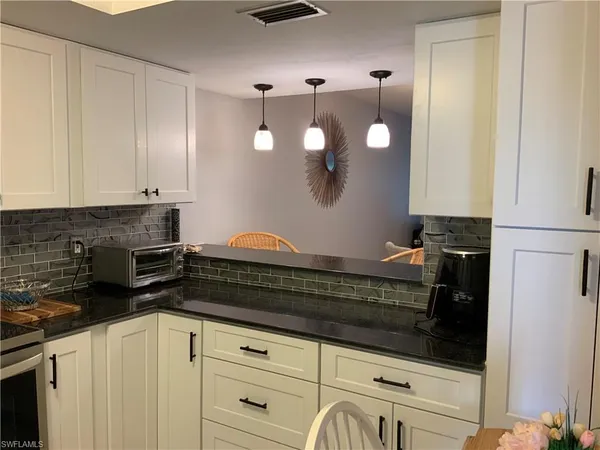 a kitchen with a dining table cabinets and stainless steel appliances