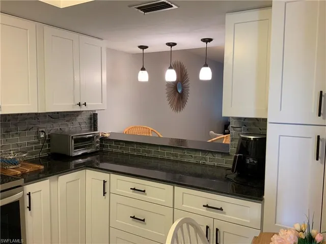 a kitchen with a dining table cabinets and stainless steel appliances