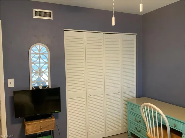 a view of a hallway with furniture and a bathroom