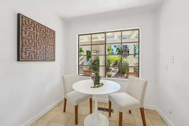 a dining room with a glass top table and chairs