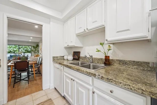 a kitchen with granite countertop a sink stove and cabinets