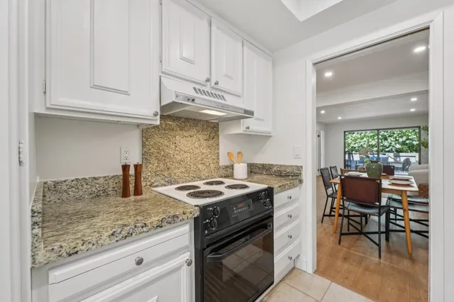 a kitchen with stainless steel appliances granite countertop a sink stove and cabinets