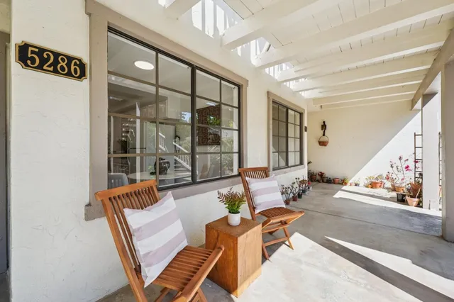 a view of balcony with two chairs and potted plants