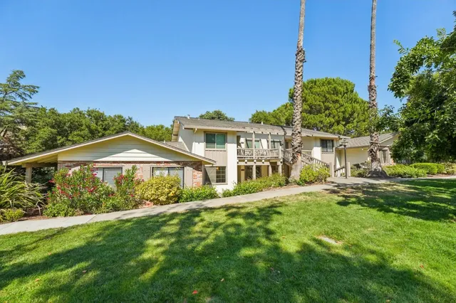 a view of a house with a yard and potted plants