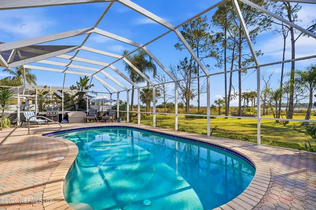 a view of a swimming pool with a patio and a yard