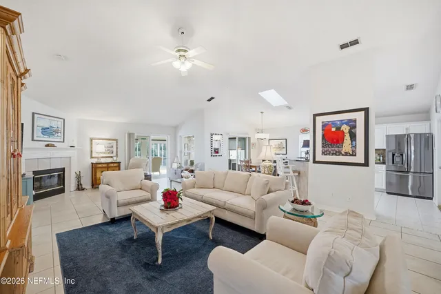 a living room with furniture a fireplace and a flat screen tv