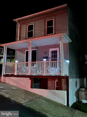 a view of a house with wooden deck and furniture