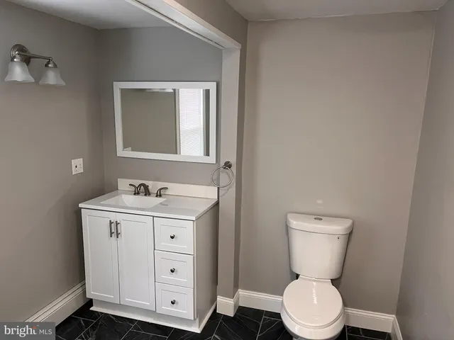 a bathroom with a toilet a sink and mirror
