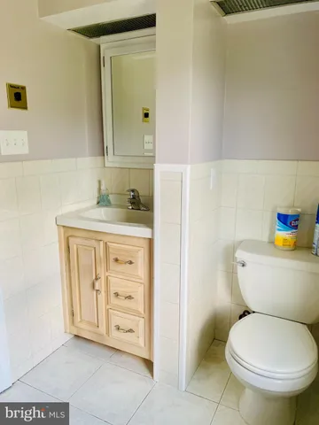 a bathroom with a granite countertop toilet sink and mirror