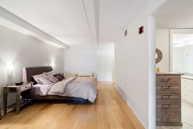 a bedroom with a bed and a wooden floor