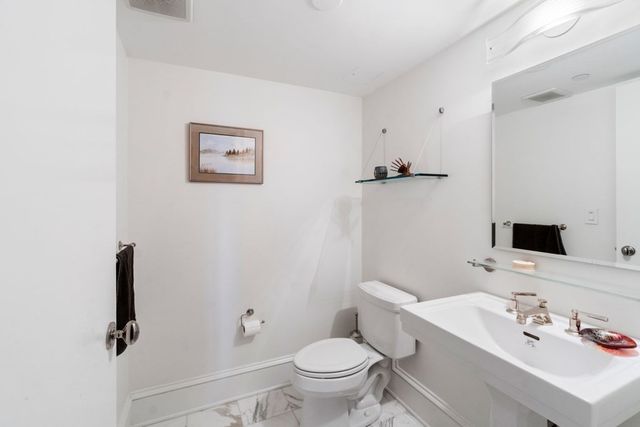 a bathroom with a sink toilet and a mirror