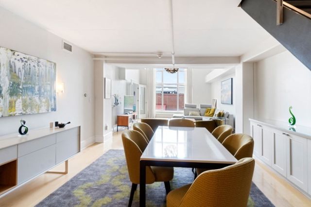 a large kitchen with a table chairs and flat screen tv