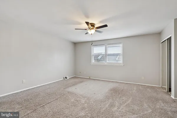 an empty room with a window and a fan