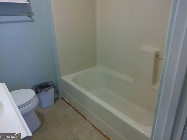 a white bath tub sitting next to a toilet