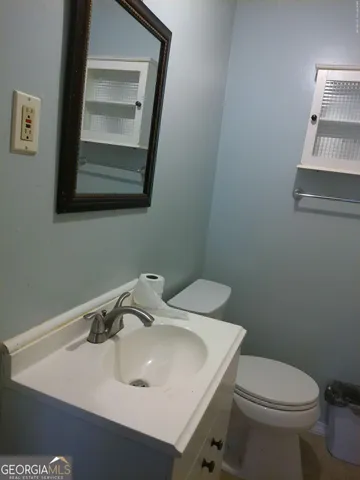 a bathroom with a sink toilet and mirror