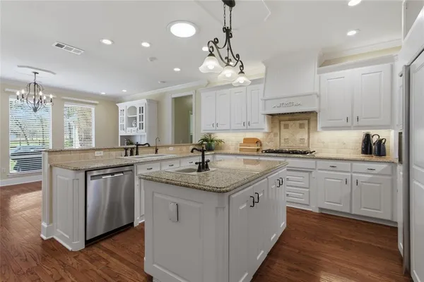 a kitchen with white cabinets and chandelier