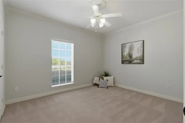 an empty room with a chandelier fan and a window