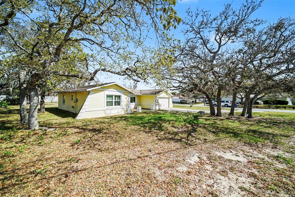 113 Ruskin Avenue Spring Hill, FL 34606 - Photo 2 of 32 a yellow house sitting in middle of forest