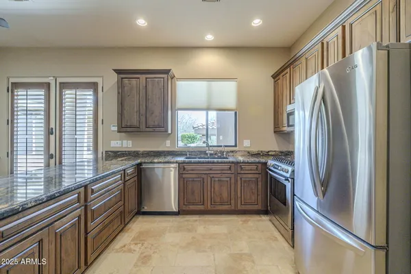 a kitchen with stainless steel appliances granite countertop a stove a sink and a microwave