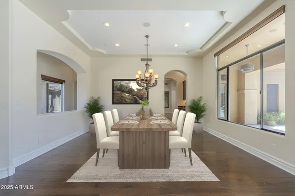 a dining room with furniture a chandelier and wooden floor