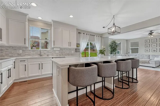 a kitchen with stainless steel appliances a chandelier and wooden floor