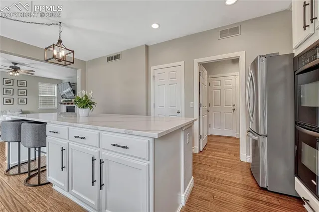 a kitchen with granite countertop white cabinets white appliances and a sink