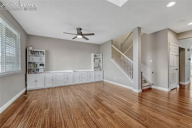 a view of staircase with wooden floor and a chandelier fan