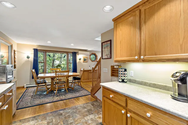 a view of a kitchen with kitchen island granite countertop a large window cabinets a sink and stainless steel appliances