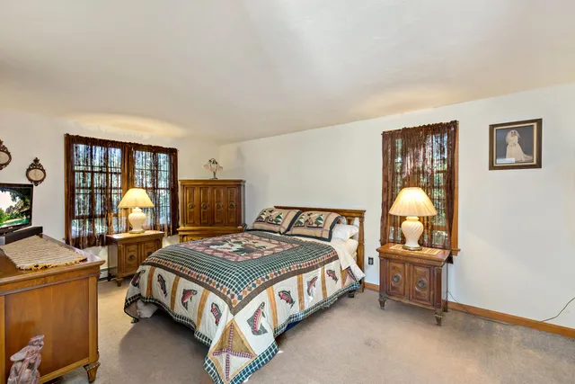 a bedroom with a bed chair and window