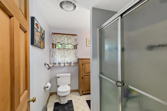 a bathroom with a granite countertop toilet a sink and shower