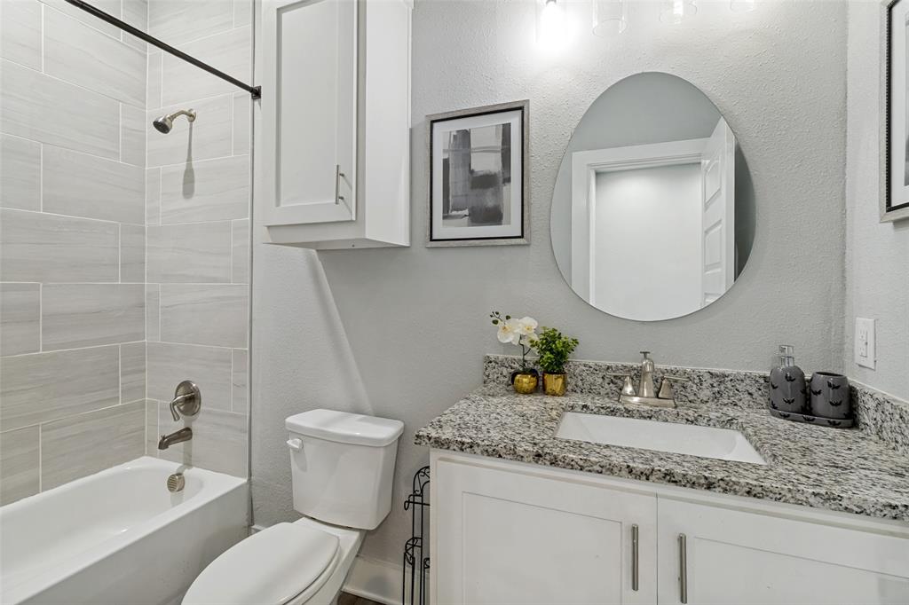 7909 Ivory Lane Dallas, TX 75216 - Photo 16 of 20 a bathroom with a granite countertop toilet a sink and a mirror