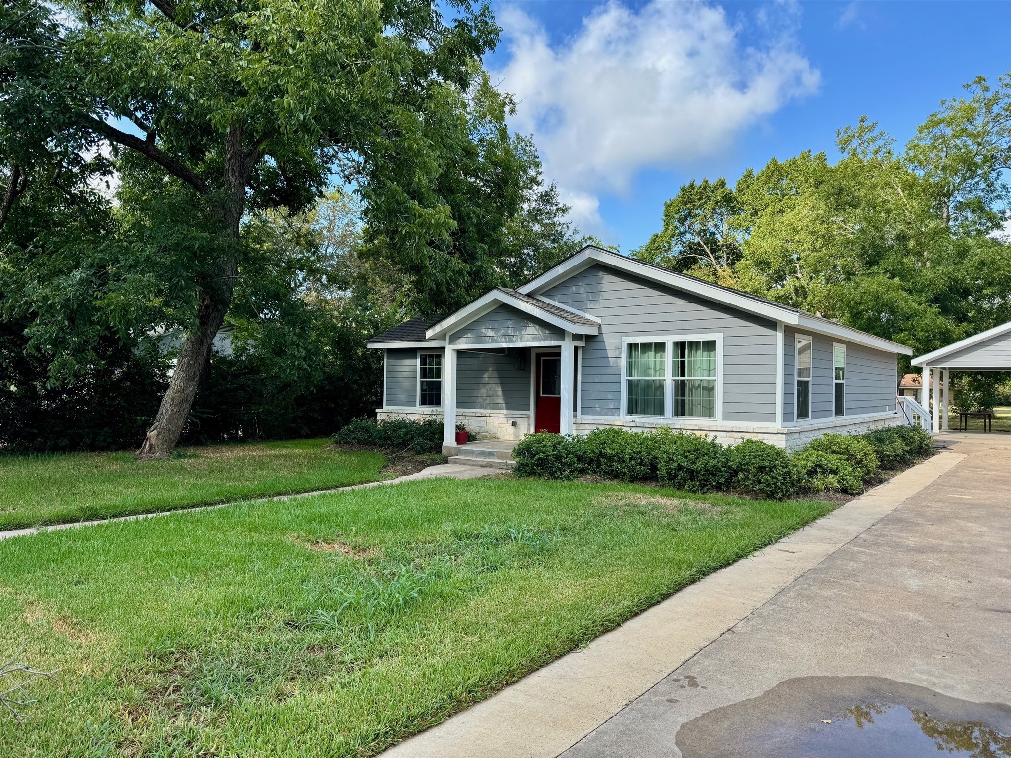 409 South 9th Street Crockett, TX 75835 - Photo 2 of 19 a view of a yard in front of a house with plants and large tree
