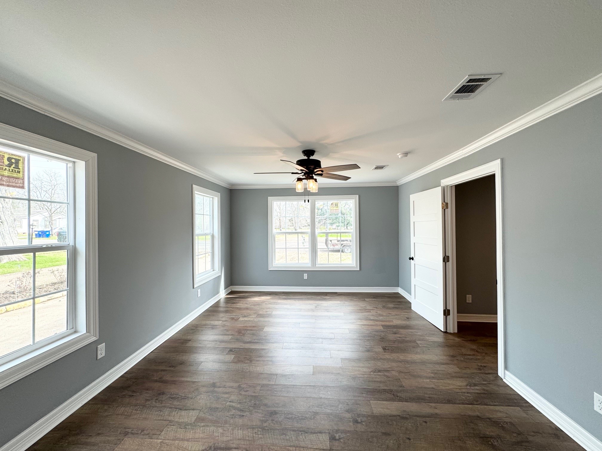 409 South 9th Street Crockett, TX 75835 - Photo 4 of 19 an empty room with wooden floor chandelier and windows