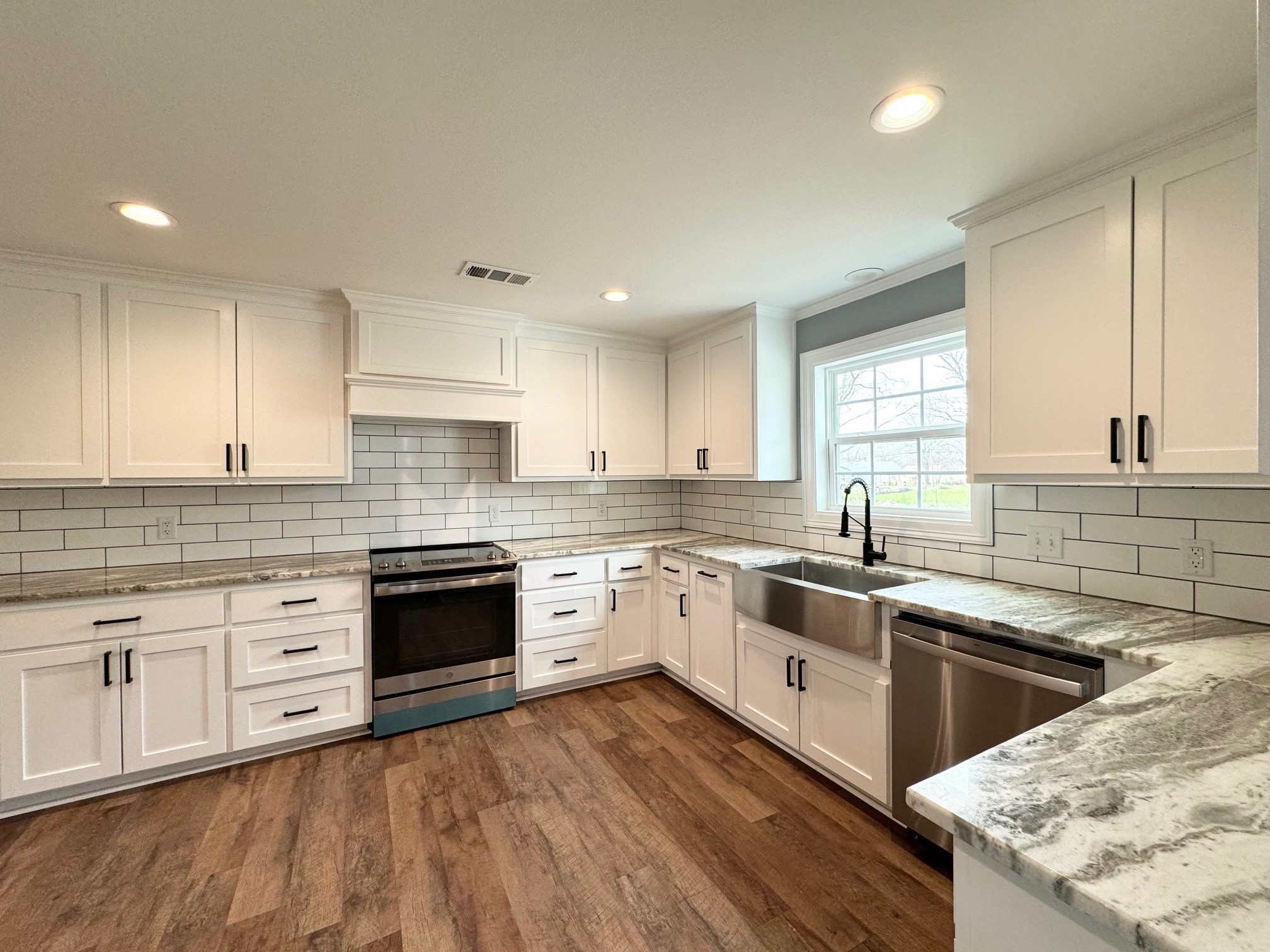 409 South 9th Street Crockett, TX 75835 - Photo 6 of 19 a kitchen with a sink stove cabinets and wooden floor