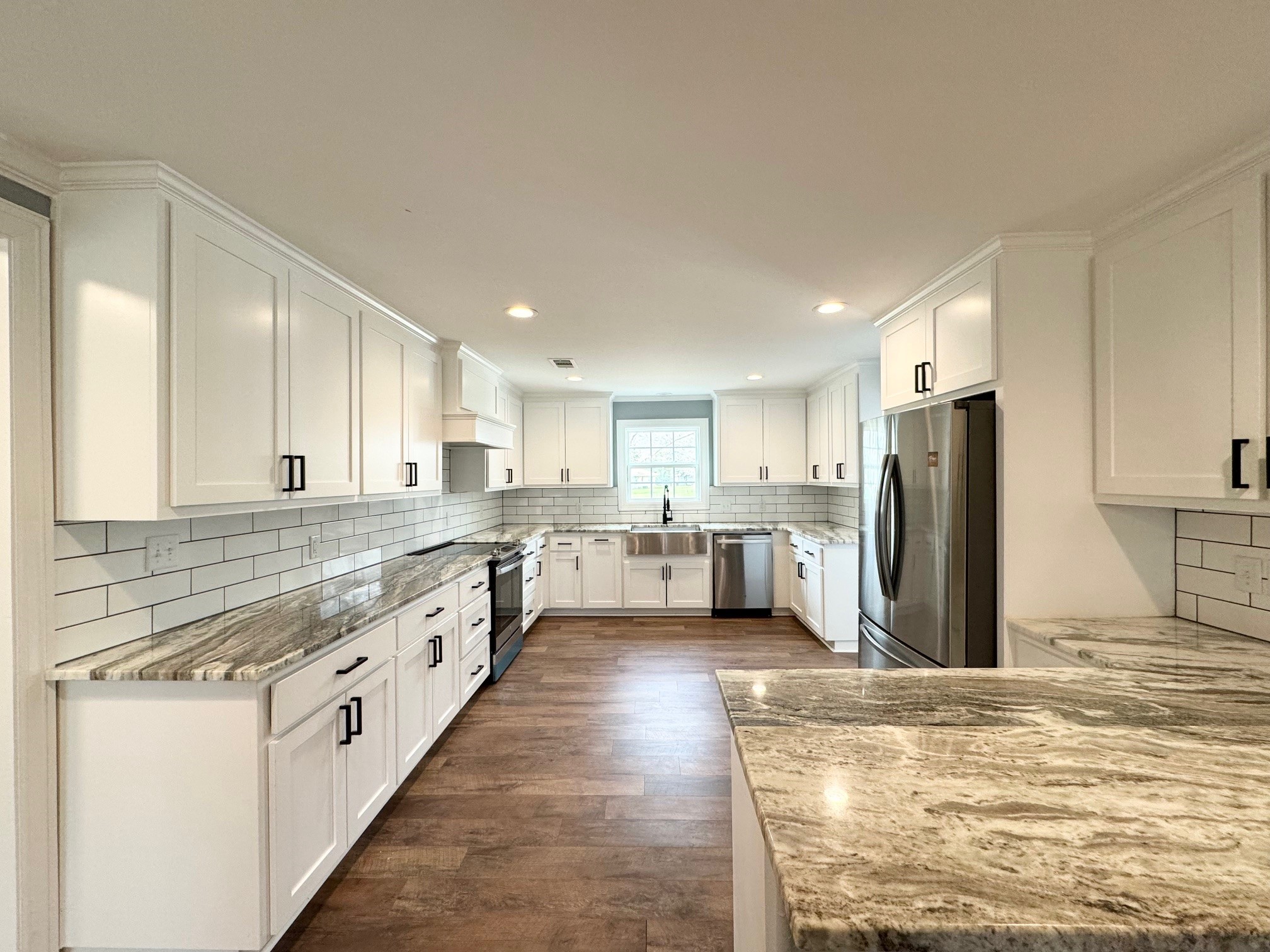 409 South 9th Street Crockett, TX 75835 - Photo 7 of 19 a large kitchen with stainless steel appliances kitchen island granite countertop a refrigerator and a stove top oven