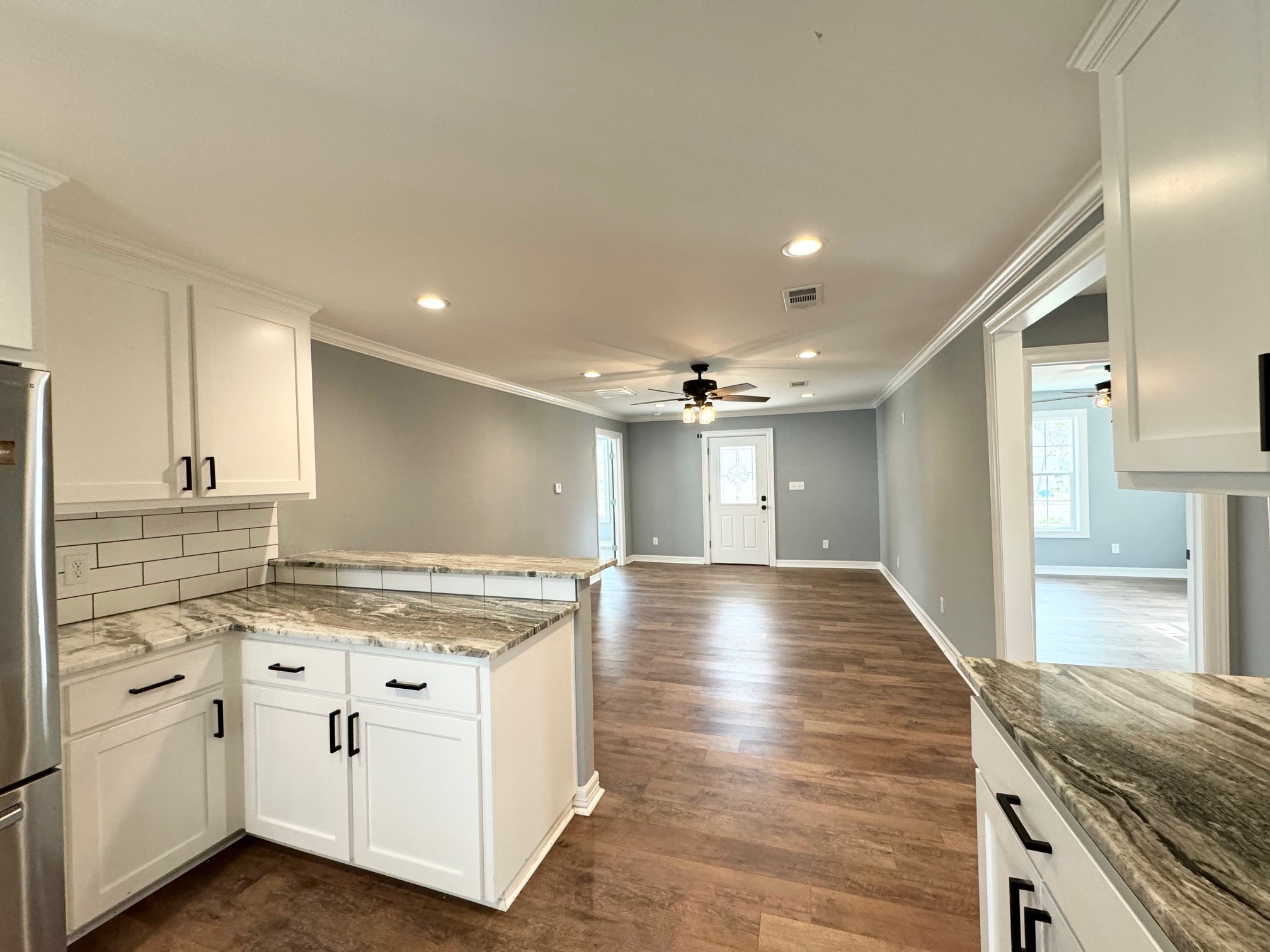 409 South 9th Street Crockett, TX 75835 - Photo 8 of 19 a view of a kitchen with a stove wooden floor and a kitchen space