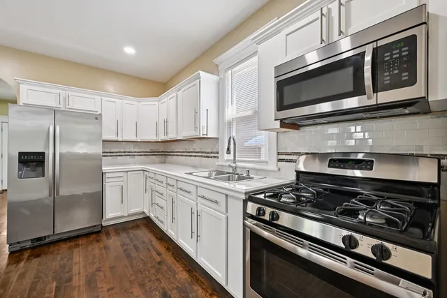 a kitchen with stainless steel appliances and white cabinets