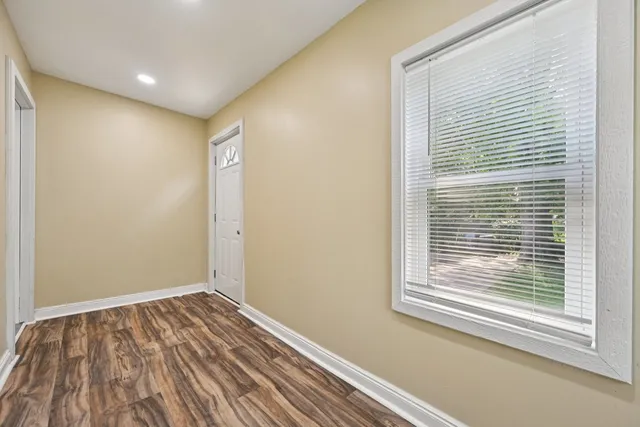 a view of a room with wooden floor and a window