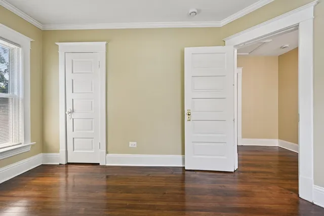an empty room with wooden floor & windows and bathroom
