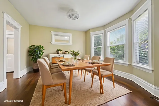 a dining room with furniture potted plants and wooden floor
