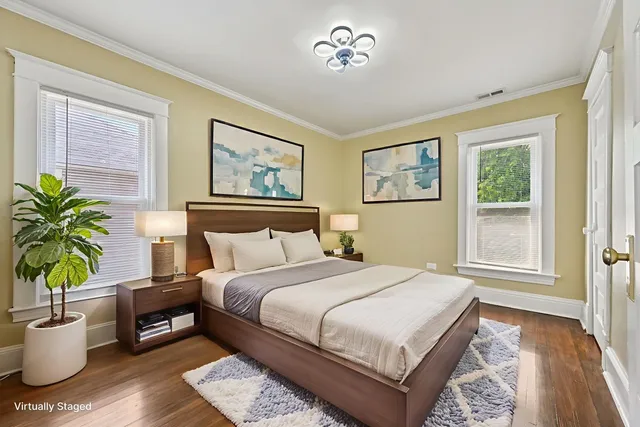 a bedroom with a large bed a potted plant and a window