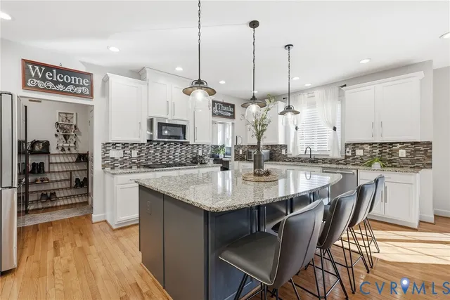 a open kitchen with stainless steel appliances kitchen island granite countertop a stove a sink and a wooden cabinets